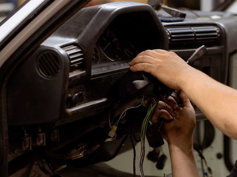 Mecánico de coches arreglando la electrónica de un coche