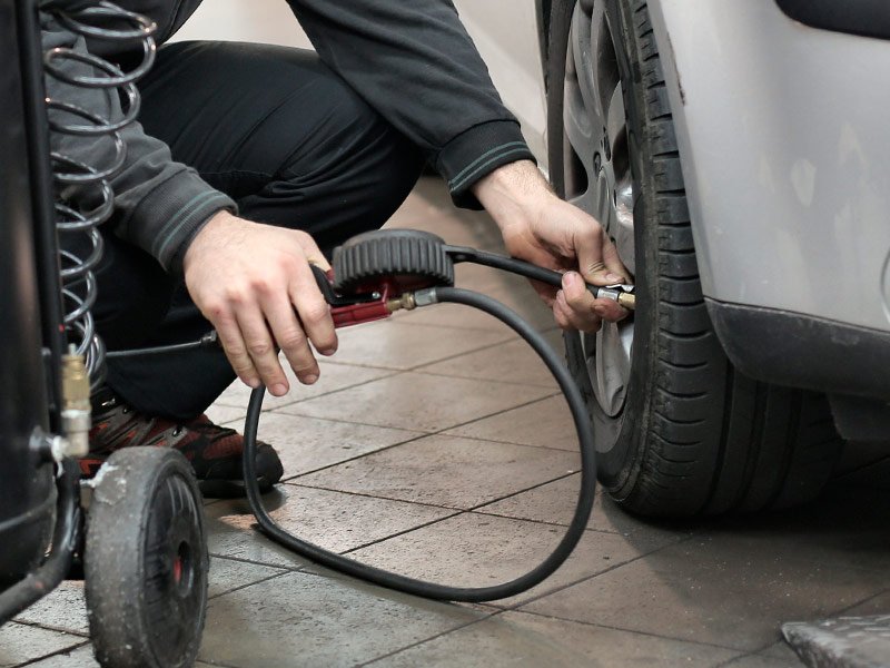 Mecánico hinchando neumático de un coche en Talleres Mario en Burgos